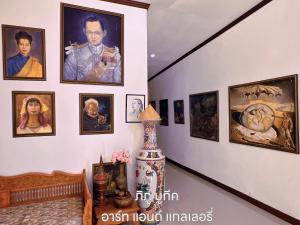 a hallway with a bunch of pictures on a wall at Phiphu Art and Gallery Boutique Sukhothai in Sukhothai