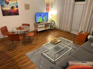 SalisburyにあるSunshine Threeのソファとテーブルとテレビのあるリビングルーム