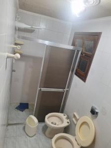 a small bathroom with a toilet and a sink at Casa mami 800 mts do mar in Capão da Canoa +26 photos