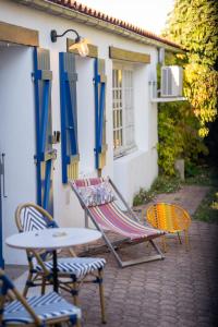 two chairs and a table in front of a building at Charmant studio rénové in La Faute-sur-Mer