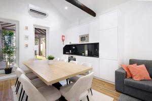 ein Esszimmer und ein Wohnzimmer mit einem Holztisch und Stühlen in der Unterkunft Villa with Private Pool, BBQ & Patio in Vila Nova de Gaia