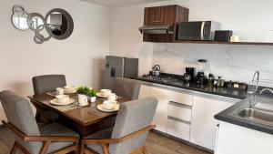 a kitchen with a wooden table with chairs and a kitchen counter at Bonito Departamento en Metepec in San Miguel Totocuitlapilco