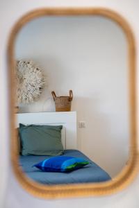 a mirror reflection of a bed with a blue pillow at Charmant studio rénové in La Faute-sur-Mer