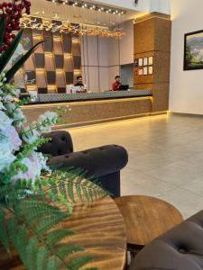 a restaurant with a waiting room with chairs and a counter at Swan Garden Resort Hotel in Melaka