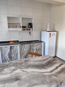 アラカジュにあるResidencial Laize & Lucasのテーブルと白い冷蔵庫のあるキッチン