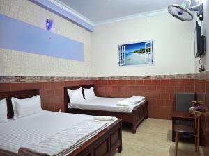 ein Zimmer mit zwei Betten und einem Fenster in der Unterkunft Minh Hồng Hotel in Ho-Chi-Minh-Stadt