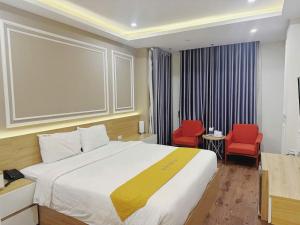 a hotel room with a bed and two red chairs at Hotel Villa Ju in Hanoi