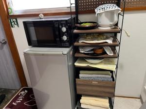 a microwave sitting on top of a refrigerator at D-pdal Inn - Vacation STAY 39054v in Tokyo