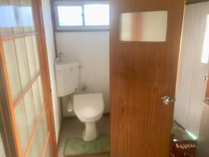 a bathroom with a toilet and a wooden door at D-pdal Inn - Vacation STAY 39054v in Tokyo