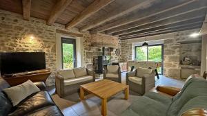 a living room with a couch and a tv at Chez marie-louise in Fromental