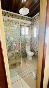 a bathroom with a shower and a toilet at Casa com piscina perto da praia in Rio Grande