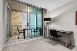 a dining room with a table and chairs and a window at 2-Bed City Retreat with Gym and Pool Access in Adelaide