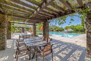 a patio with a table and chairs and a pool at @ Marbella Lane - 4BR Mediterranean-style Home in Newport Beach