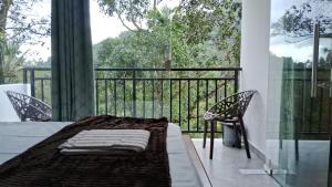 een kamer met een balkon met een tafel en stoelen bij The Lovely Home Stay in Munnar