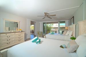 a bedroom with two beds and a ceiling fan at Eldorado E104 · Spacious 1BD wPool at Kaanapali in Kahana +60 photos