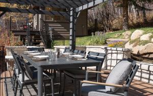 a dining table and chairs under a pergola at Orion Lodge in Steamboat Springs