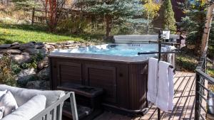 a hot tub on a wooden deck with at Orion Lodge in Steamboat Springs