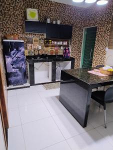 a kitchen with a black counter and a table at Casa Temporada in Porto Seguro +26 photos