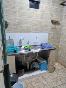 a kitchen sink with two faucets on a counter at Casa Temporada in Porto Seguro