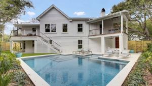 a house with a swimming pool in front of a house at 6 36th Avenue by AvantStay Stunning Private Pool in Isle of Palms