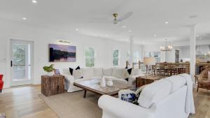 a living room with white furniture and a table at 6 36th Avenue by AvantStay Stunning Private Pool in Isle of Palms