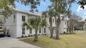 a white house with palm trees in front of it at 6 36th Avenue by AvantStay Stunning Private Pool in Isle of Palms