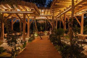 a wooden walkway leading to a restaurant at night at Hotel Boutique Maitta en Doradal Antioquia in Doradal