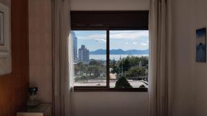 a window in a room with a view of a city at Aconchego Floripa Vista Mar in Florianópolis