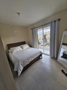 een slaapkamer met een bed en een groot raam bij Casa Alta California Pet Friendly in Tlajomulco de Zúñiga