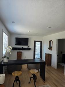 uma secretária com dois bancos numa sala de estar em Comfortable Luxury Studio em Northridge