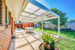 an outdoor patio with a white pergola at StayAU 4BR Family-Friendly Home near Deakin Uni in Whittington