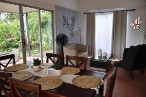 a living room with a dining room table and chairs at Arenals Peak Villas in Agua Azul