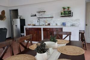 a kitchen with a table and chairs and a kitchen with a refrigerator at Arenals Peak Villas in Agua Azul +21 photos
