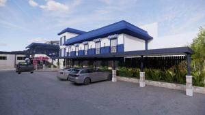 CalasiaoにあるCox Hotelの建物前の駐車場に駐車した車2台