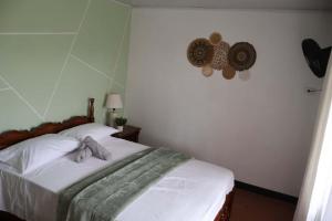a bedroom with a bed with a blanket on it at Arenals Peak Villas in Agua Azul