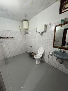 a bathroom with a toilet and a sink at Kalanja Greens Nilagiri Villa in Ooty