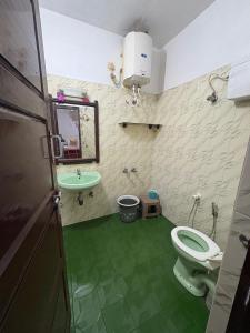 a bathroom with a toilet and a sink at Kalanja Greens Nilagiri Villa in Ooty