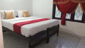 a bed sitting in a room with a window at Kalanja Greens Nilagiri Villa in Ooty +4 photos