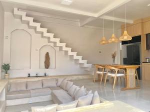 a living room with a couch and a staircase at The Sangka House in Mendaya