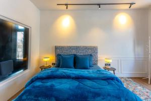 a bedroom with a blue bed and a large window at The Zoey Villa, with Central Heating, Bonfire, BBQ & Complimentary Breakfast in Gulmarg