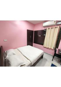 a bedroom with a bed in a pink room at CHETTINAD HOMESTAy in Chidambaram