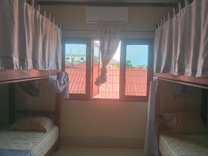 two bunk beds in a room with two windows at Ning Ning Bungalow in Don Det