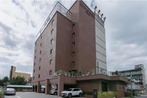 een gebouw waar auto's voor geparkeerd staan bij H Avenue Hotel Jeonju Terminal in Jeonju