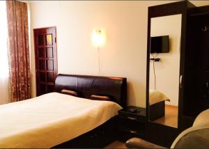 a hotel room with a bed and a mirror at Leli in Sighnaghi