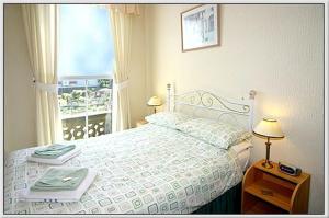 1 dormitorio con cama blanca y ventana en Belle View, en Skegness
