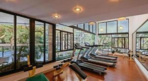 a gym with a bunch of cardio machines in a room with windows at Nanhai Oil Hotel in Zhuhai