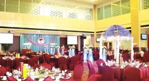 a banquet hall with red chairs and tables in a room at Xiangtan Xintian International Hotel in Yisuhe