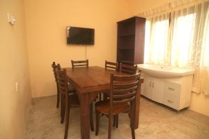 ein Esszimmer mit einem Tisch, Stühlen und einem Waschbecken in der Unterkunft Sanmi Runway View Resort in Kimbulapitiya