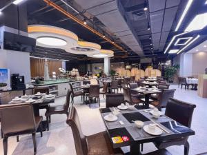 Un comedor con mesas y sillas y un restaurante. en Shenzhen Jin Mao Yuan Hotel, en Sanjiaolou