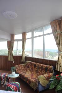a living room with a couch and a large window at Thu Van Apartment in Xuan An